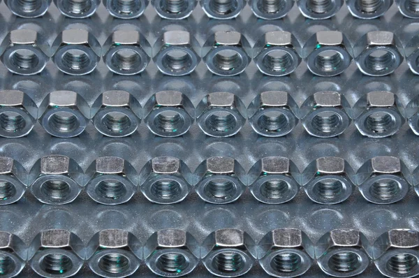 定期的なパターンのシート表面上のナッツ — ストック写真