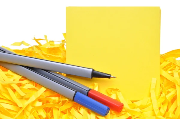 Markers with yellow sticky notes and shredded papers — Stock Photo, Image