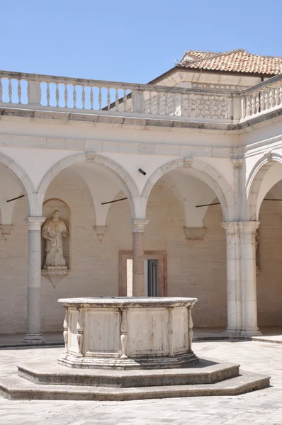 Двор Бенедиктинского монастыря в Монте-Кассино, каменный фонтан и аркады — стоковое фото