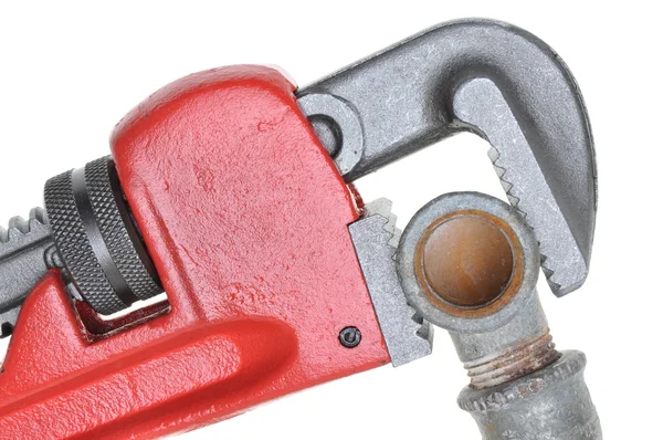 Red plumbers pipe wrench and plumbing component — Stock Photo, Image