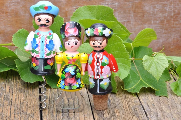 Sacacorchos decorativos húngaros, botella de vino y copa de vino en la mesa de madera con ramas verdes vid —  Fotos de Stock