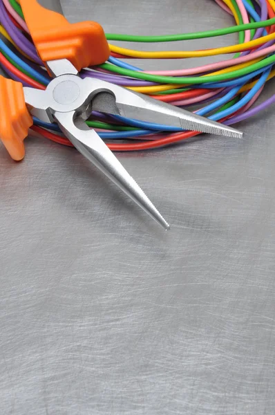 Tools for electrician and cables on grey metal surface — Stock Photo, Image