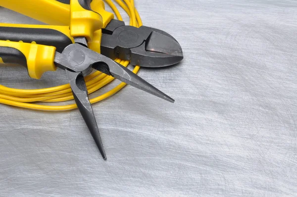 Yellow electrical tools and cables on metal surface with place for text — Stock Photo, Image