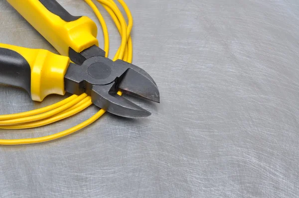 Gele elektrische gereedschappen en kabels op metalen oppervlak met plaats voor tekst — Stockfoto