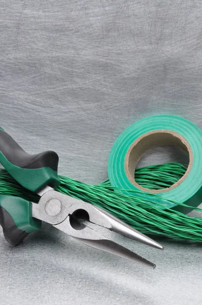 Green electrical tools and cables on metal surface — Stock Photo, Image