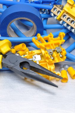 Pense ile elektrik bileşen kitini gri metal zemin üzerine