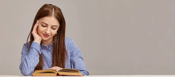 Ευτυχισμένη νεαρή γυναίκα διαβάζει βιβλία ιστορίας στο τραπέζι στο σπίτι — Φωτογραφία Αρχείου