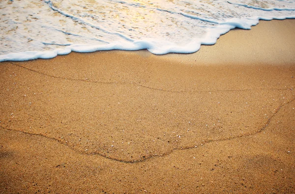 Sand på stranden vid havet vid soluppgången — Stockfoto