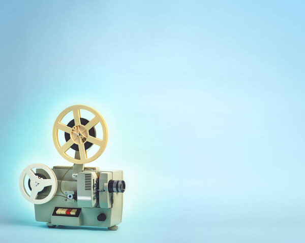 Old cinema projector on blue background