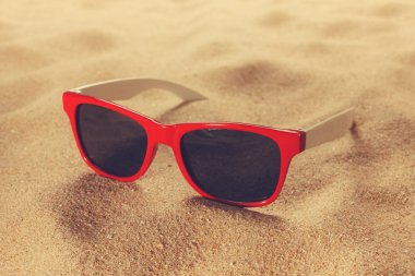 Plaj kum üzerinde güneş gözlüğü