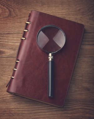 Kırmızı defter bir büyüteç ile