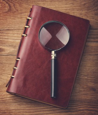Notebook with a magnifier on table