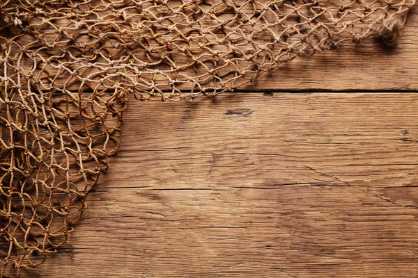 Opknoping fishnet op houten muur — Stockfoto