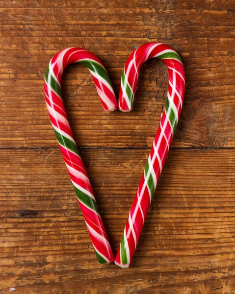 Candy canes op houten bord — Stockfoto