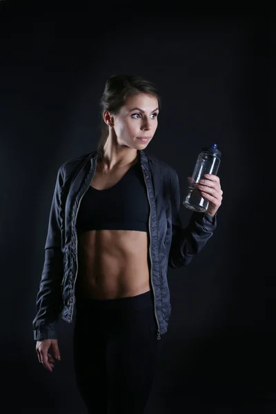 Mulher desportiva segurando beber garrafa — Fotografia de Stock