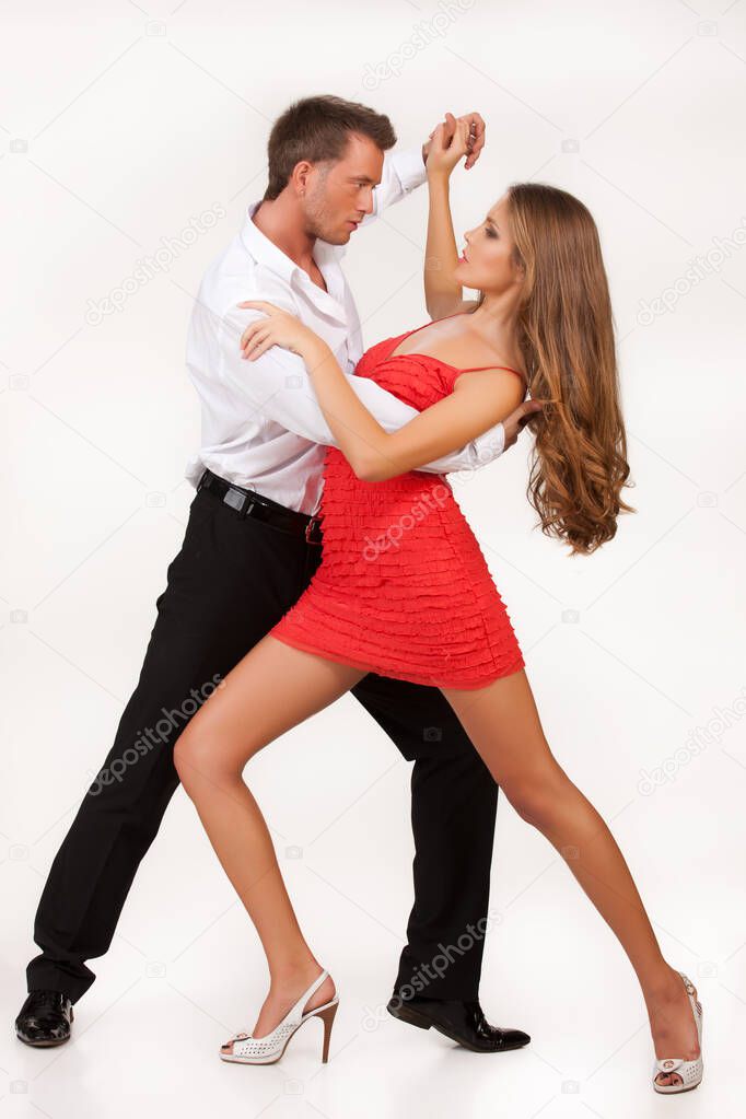 Young woman and man dancing on isolated background