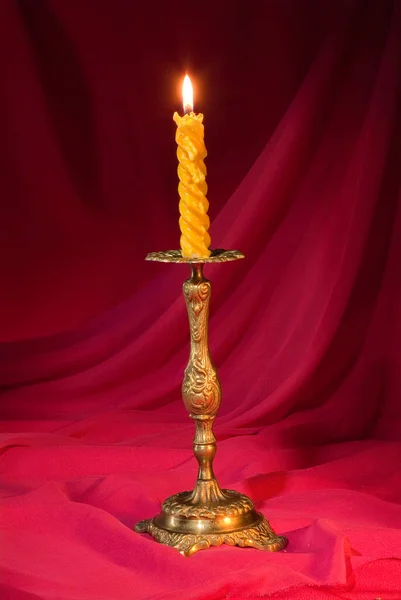 在红色面料工作室背景上的手杖上挂着蜡烛 — 图库照片