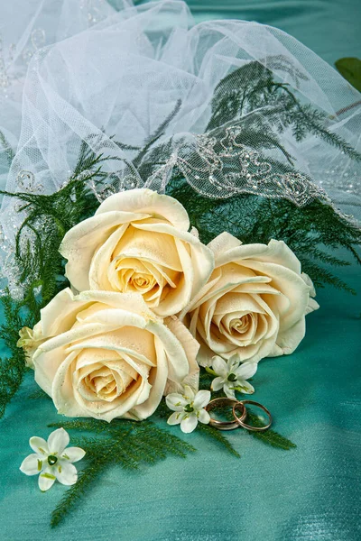 两个结婚戒指和花在面料的背景上 — 图库照片