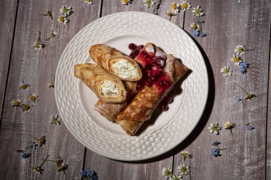 Eski ahşap bir arka planda etli gözleme ve bir fincan çay.