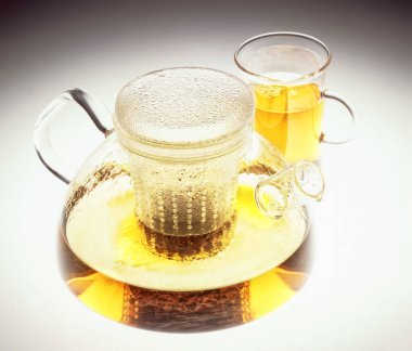  Bir fincan çay ve izole edilmiş bir stüdyo arka planında çaydanlık.