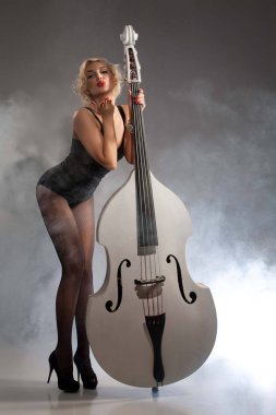 Siyah iç çamaşırlı, bas gitarlı genç kadın.