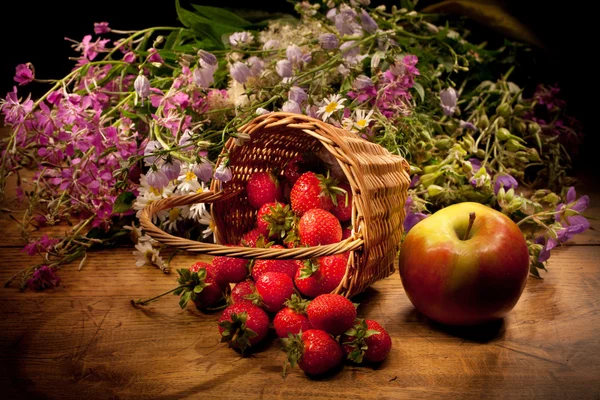 Korb mit Apfel, Erdbeere und Blumen — Stockfoto