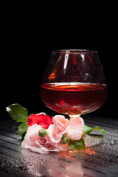Натюрморт зі склом і трояндою — стокове фото