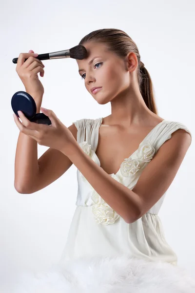 Ung kvinna tillämpa kosmetika — Stockfoto