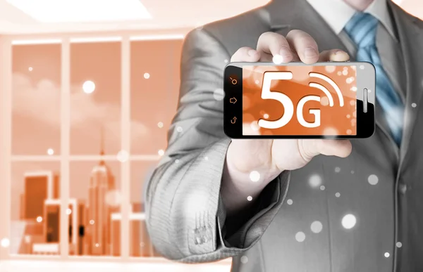 Businessman holding phone with 5G