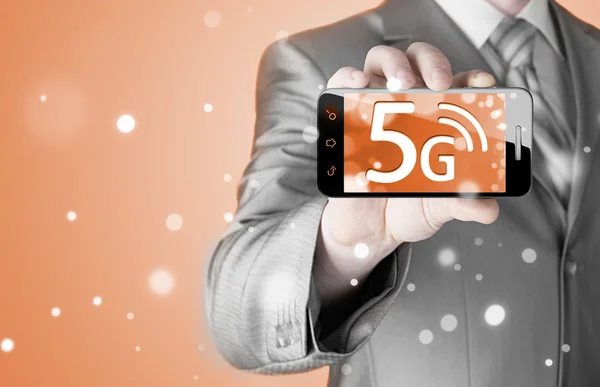 Businessman holding phone with 5G