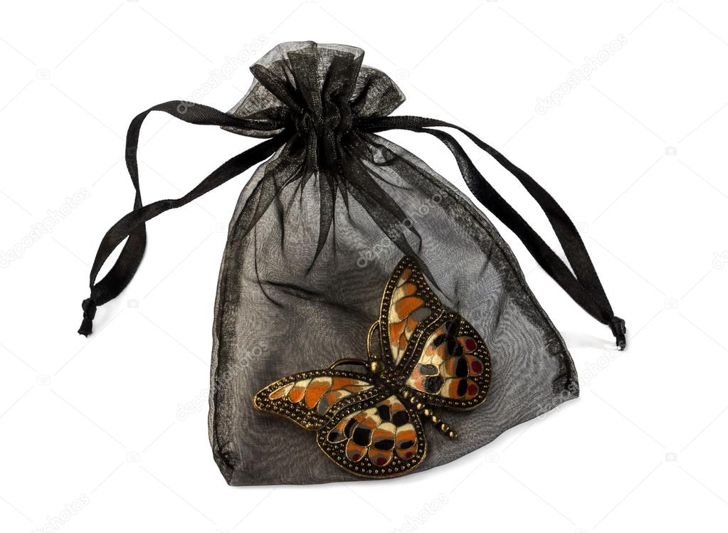 Pouch with butterfly brooch isolated over white.
