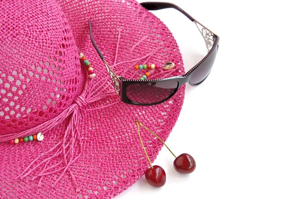 Sombrero de playa rosa, vasos y dos cerezas dulces sobre blanco . —  Fotos de Stock