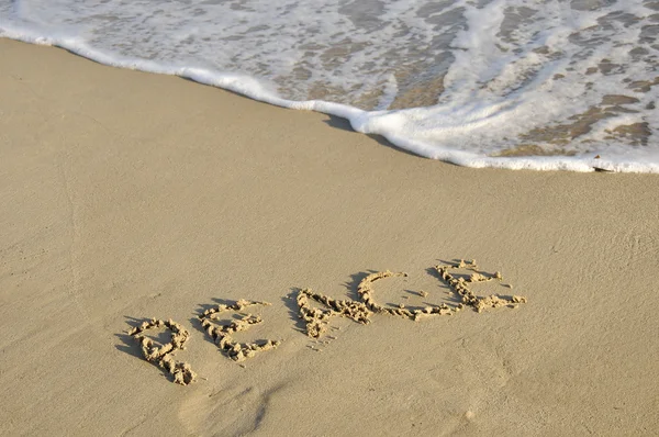 Wort "Frieden" in den Sand geschrieben. — Stockfoto
