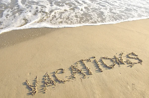 Palabra "vacaciones" escrito en la arena mojada . — Foto de Stock