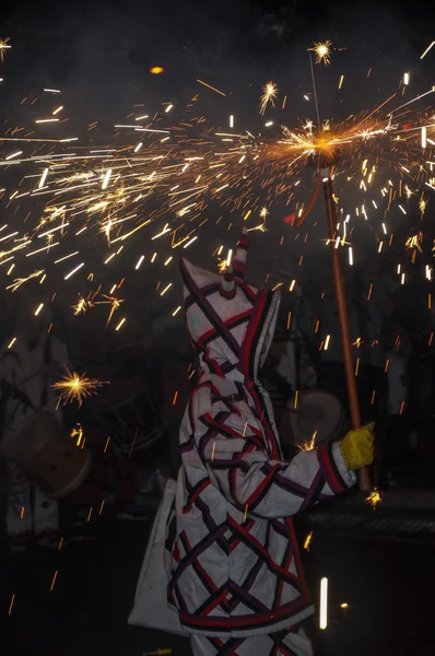 Participante del espectáculo Correfocs (fuegos artificiales) con fuegos artificiales de iluminación . Imágenes de stock libres de derechos