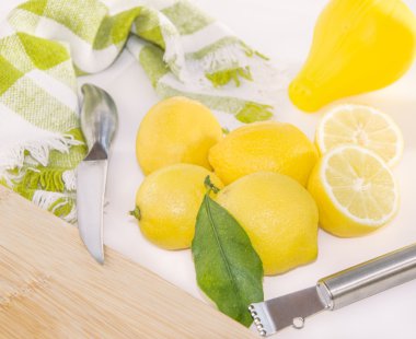 Limon, sıkacağı, rendemi, bıçak ve ahşap kesme tahtası.