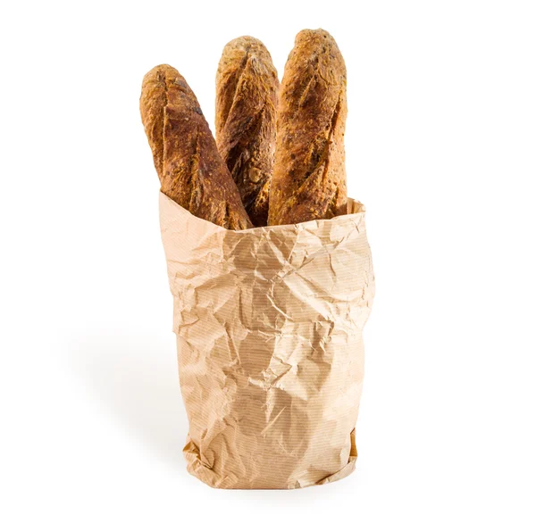 Three fresh home baked baguettes in a paper packet on white. — Stock Photo, Image