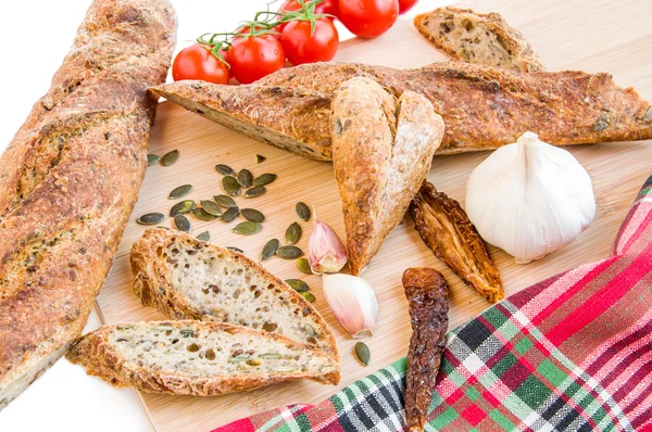 Casa baguette al forno, pomodori freschi e secchi, aglio, semi di zucca . — Foto Stock