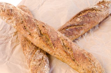 Kağıt arka plan üzerinde üç taze ev fırında baget.