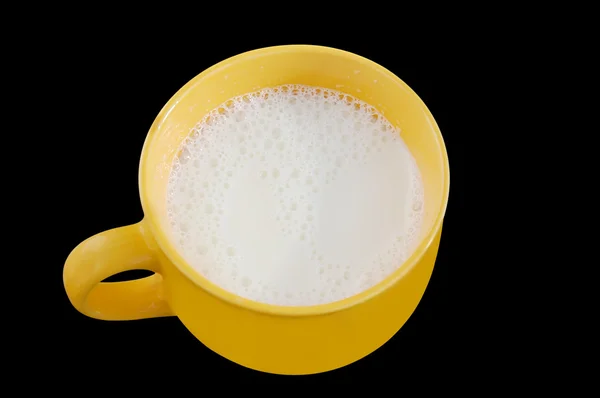 La leche fresca en la taza grande amarilla sobre el fondo negro. Ruta de recorte . — Foto de Stock