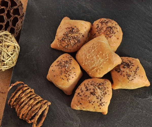 Hot and crispy homemade puff pocket pies with meat and sprinkled with sesame and chia seeds. — Stock Photo, Image