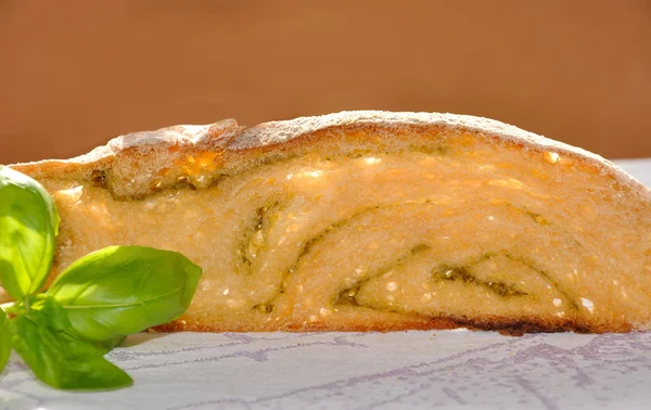 Slice of wheat bread with pesto and sprig of basil on a table. — Stock Photo, Image