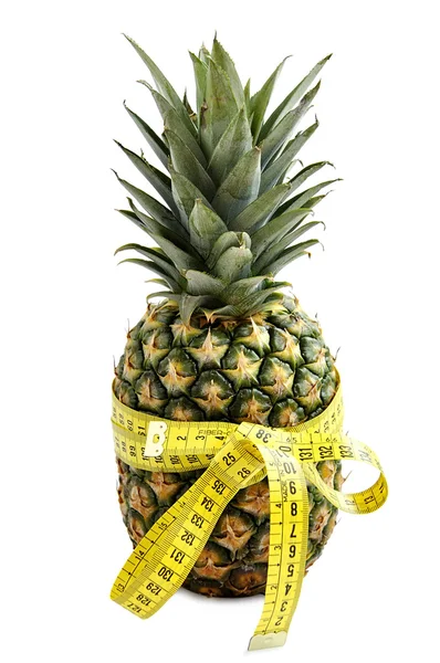 Pineapple with a bow made of measuring tape isolated over white. — Stock Photo, Image
