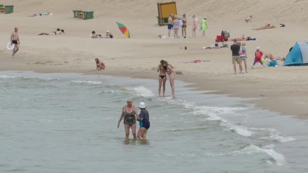 Menschen entspannen sich am Strand von Palanga — Stockvideo