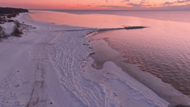 Zonsondergang in een rustige zee met bevroren kust. — Stockvideo