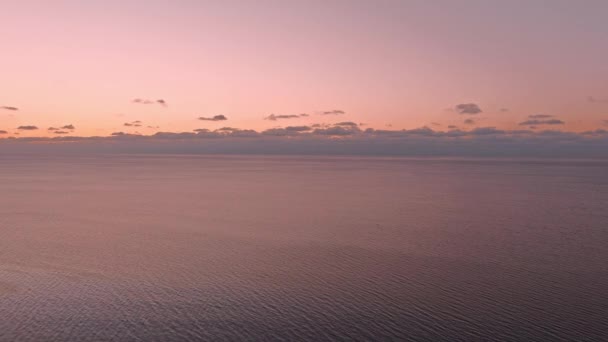 Puesta de sol en un mar tranquilo con costa congelada. — Vídeos de Stock