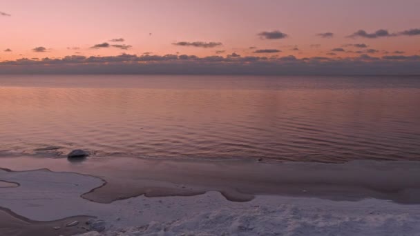Sonnenuntergang in einer ruhigen See mit gefrorener Küste. — Stockvideo