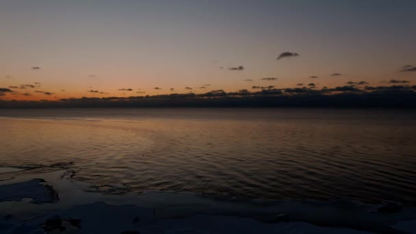 Sonnenuntergang in einer ruhigen See mit gefrorener Küste. — Stockvideo