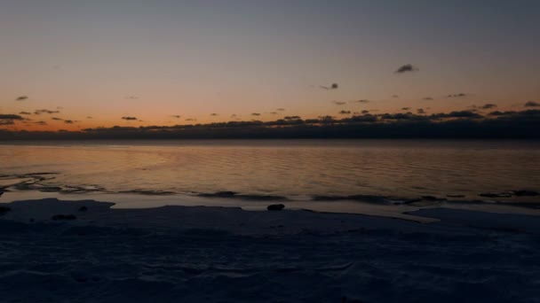 Zachód słońca w spokojnym morzu z zamarzniętym morzem. — Wideo stockowe