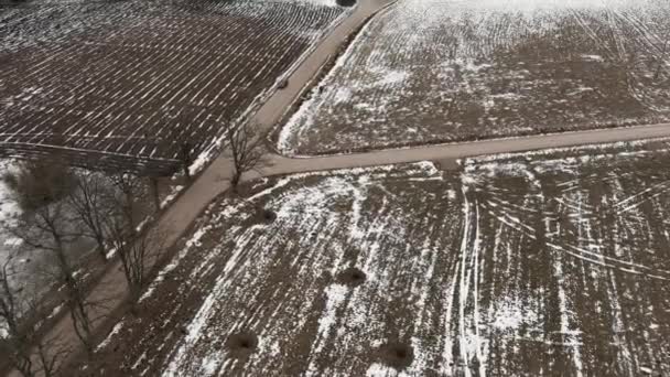 Vista aérea con campo carretera y campos de agricultura arada cubiertos de nieve — Vídeo de stock